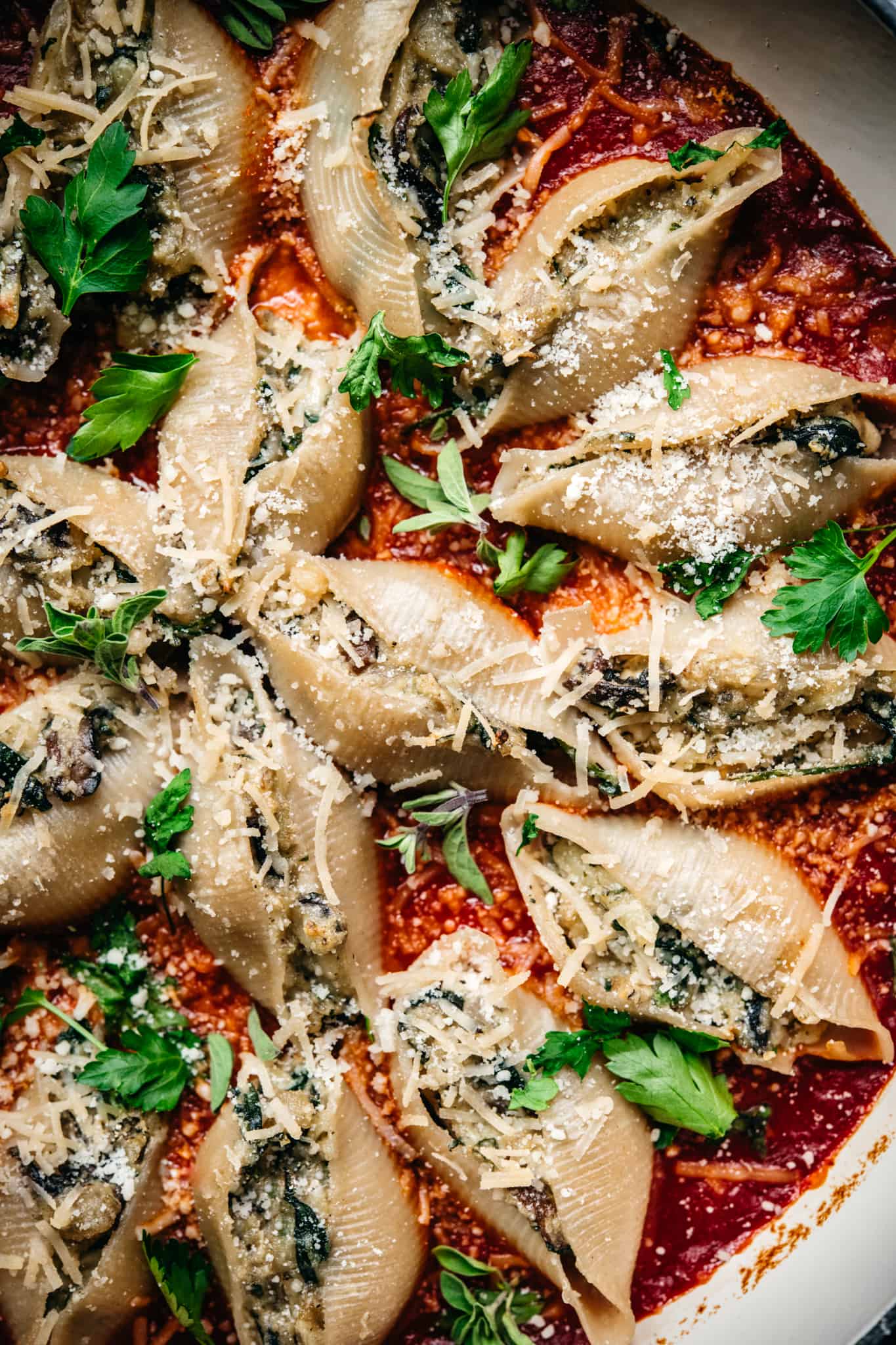 close up overhead of vegan spinach mushroom ricotta stuffed shells in marinara sauce
