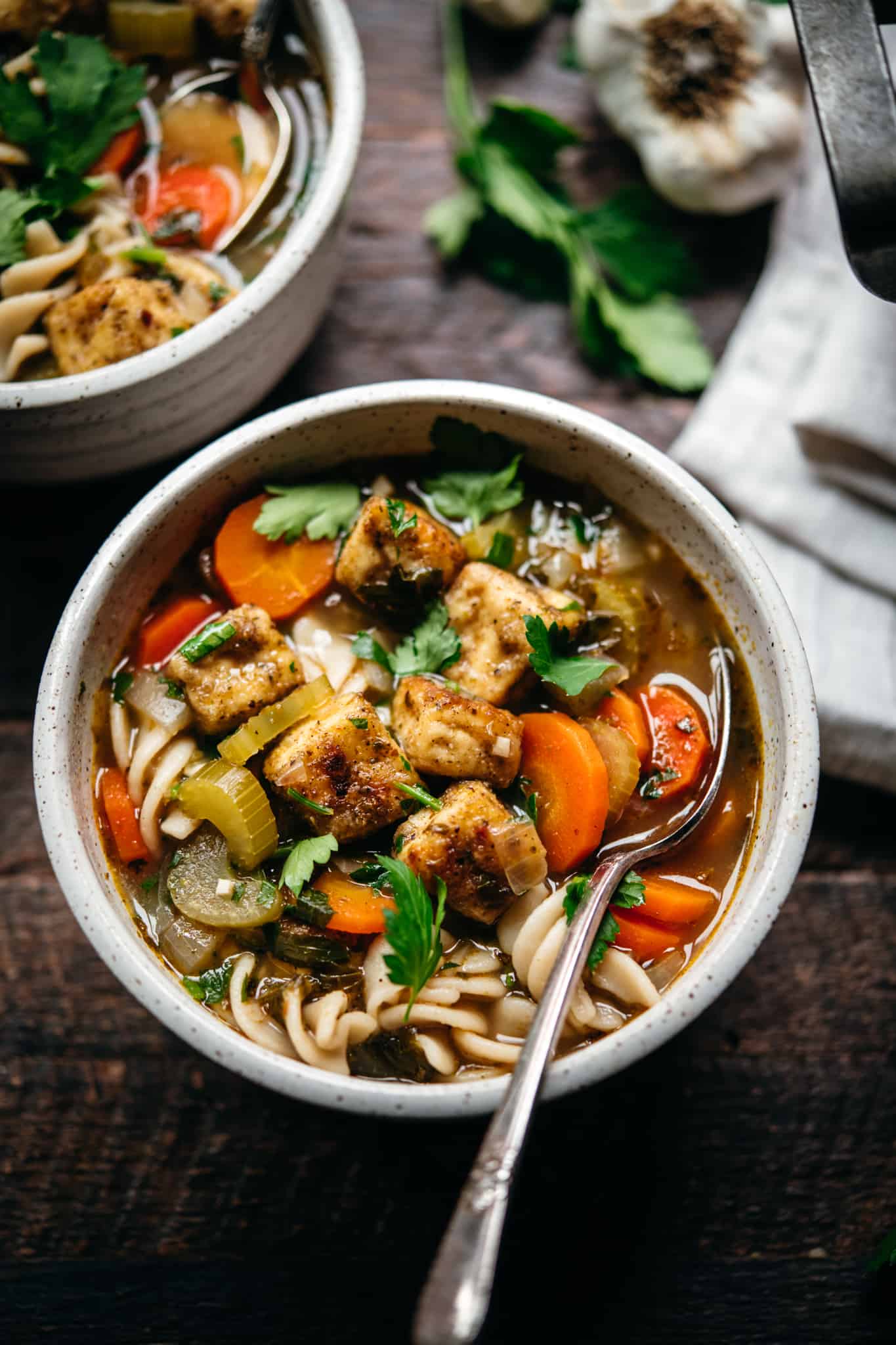 side view of vegan chicken noodle soup with crispy baked tofu