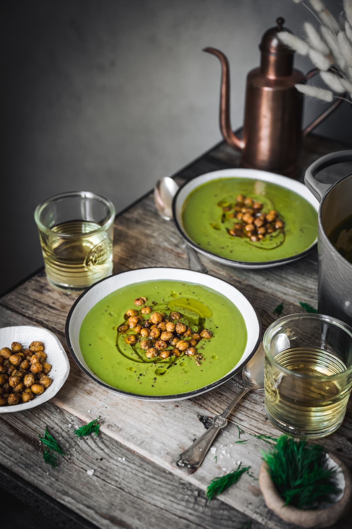 side view of creamy vegan broccoli soup in white bowls