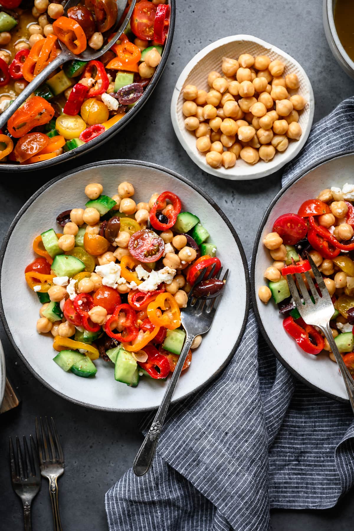 overhead view of greek chickpea salad in bowls with forks