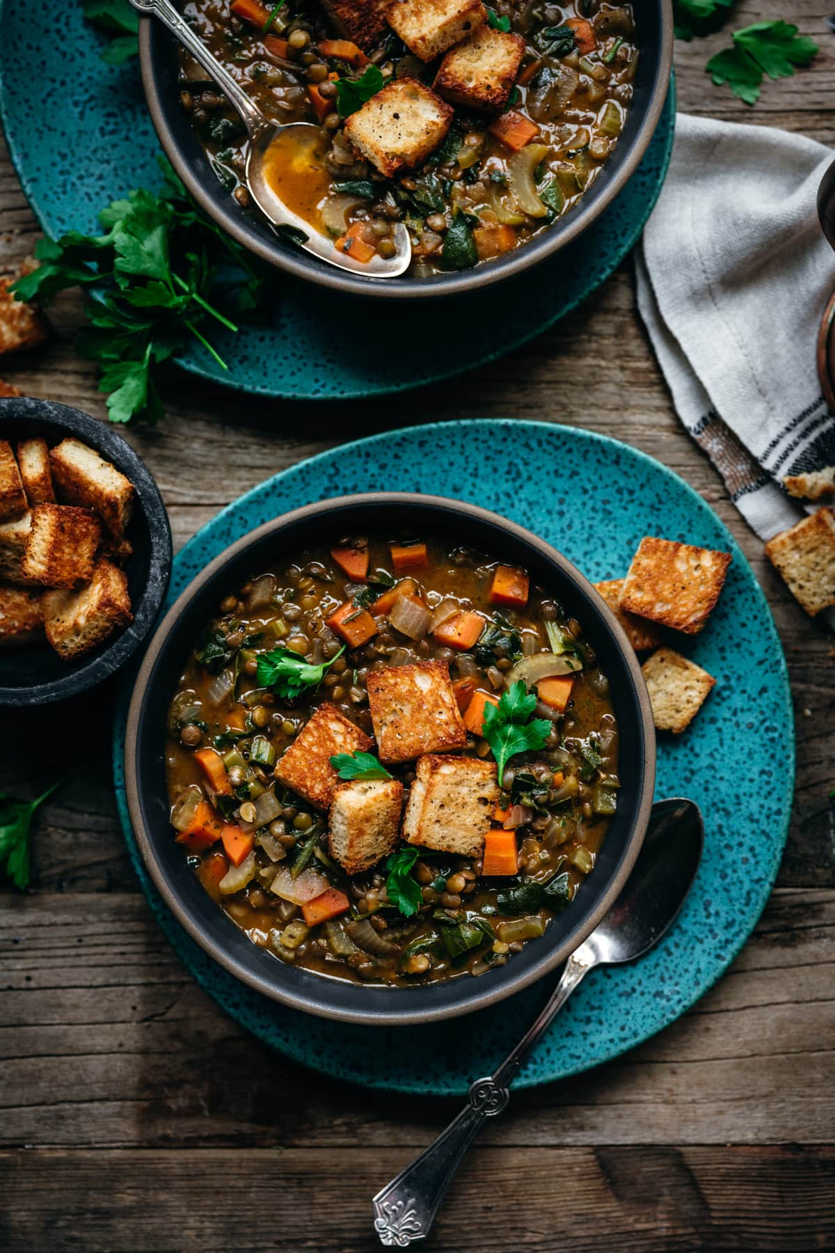 overhead view of vegan lentil stew topped with garlicky croutons