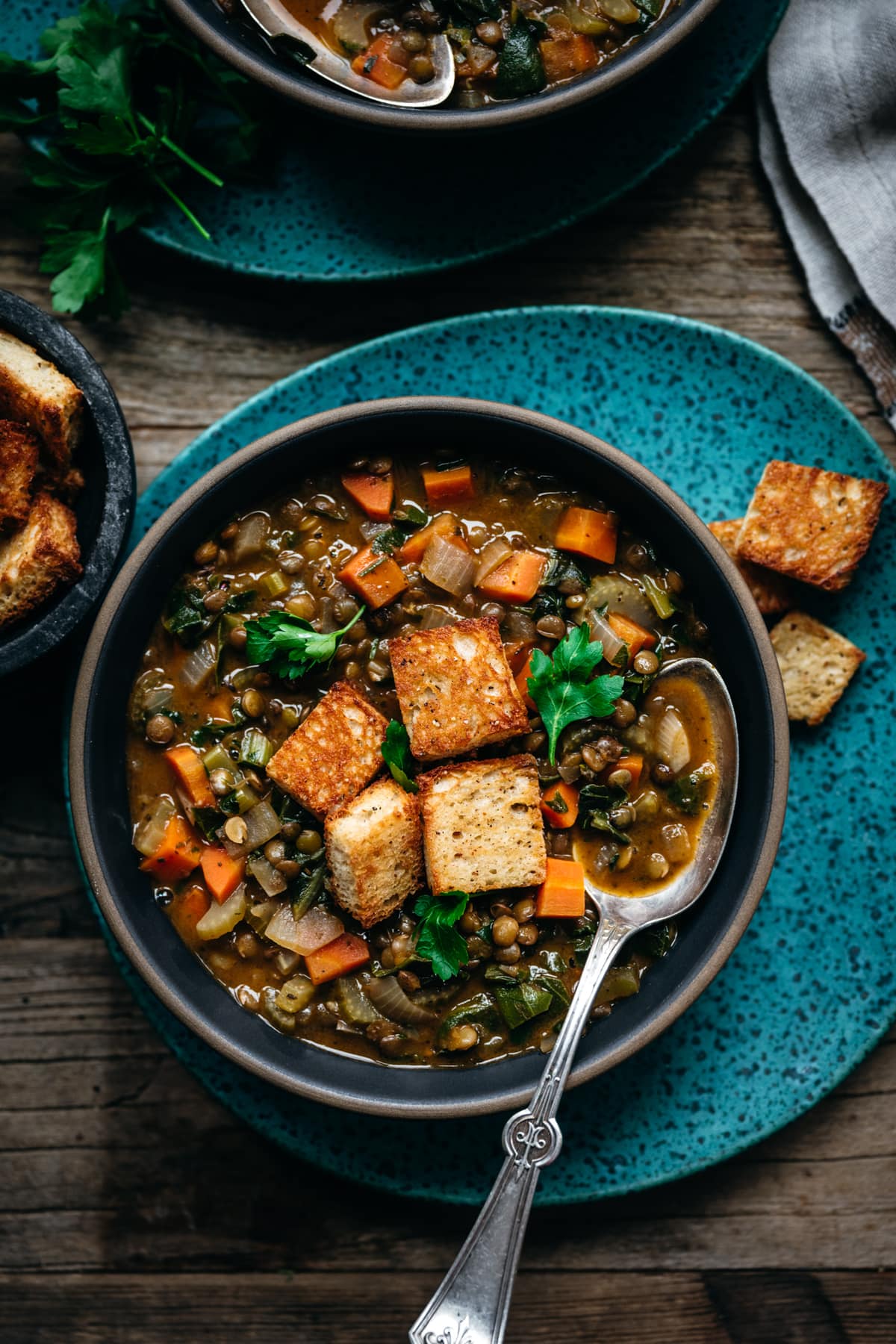 overhead view of vegan lentil stew topped with garlicky croutons