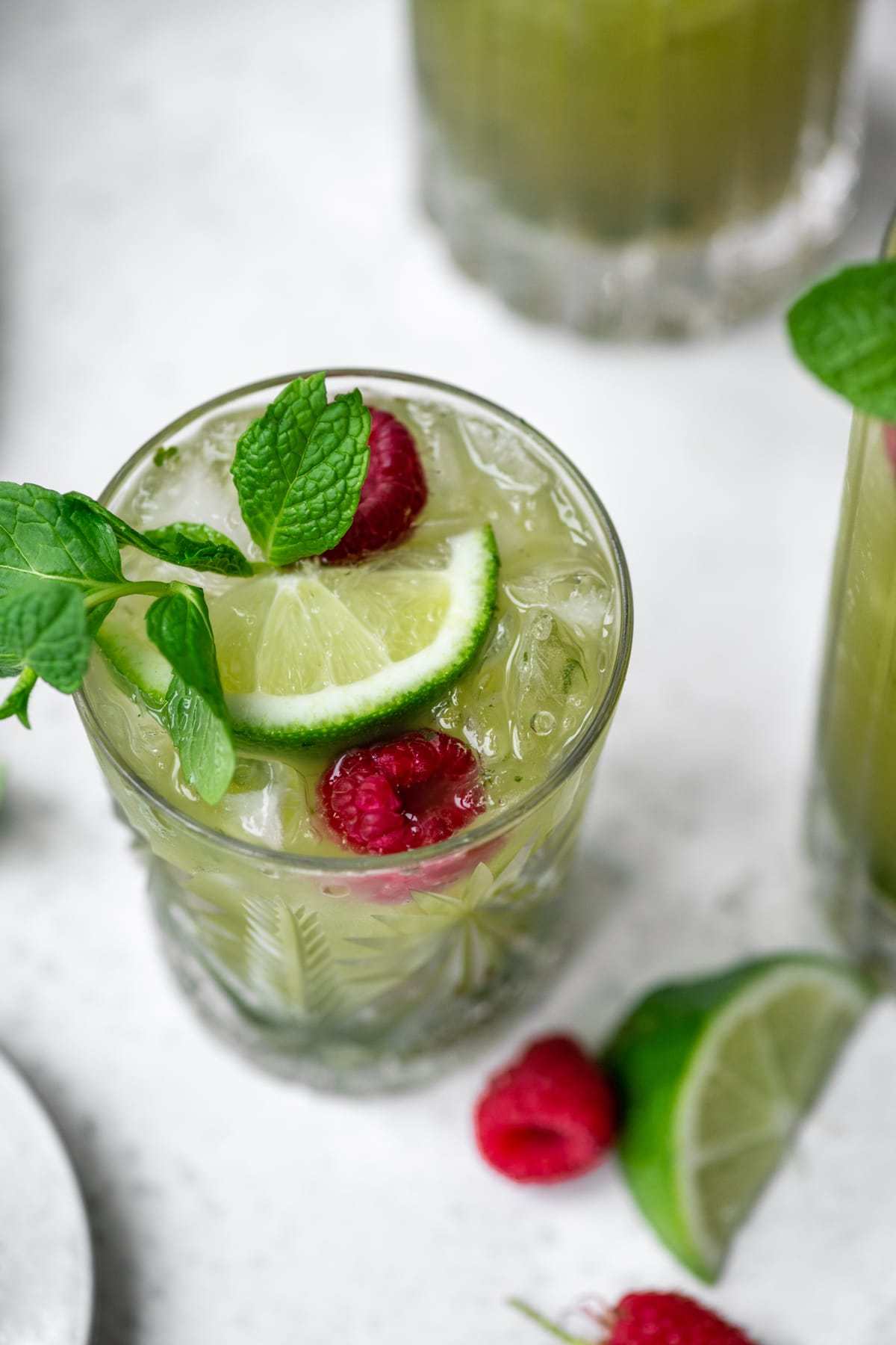 close up view of nonalcoholic matcha drink in glass with lime and mint
