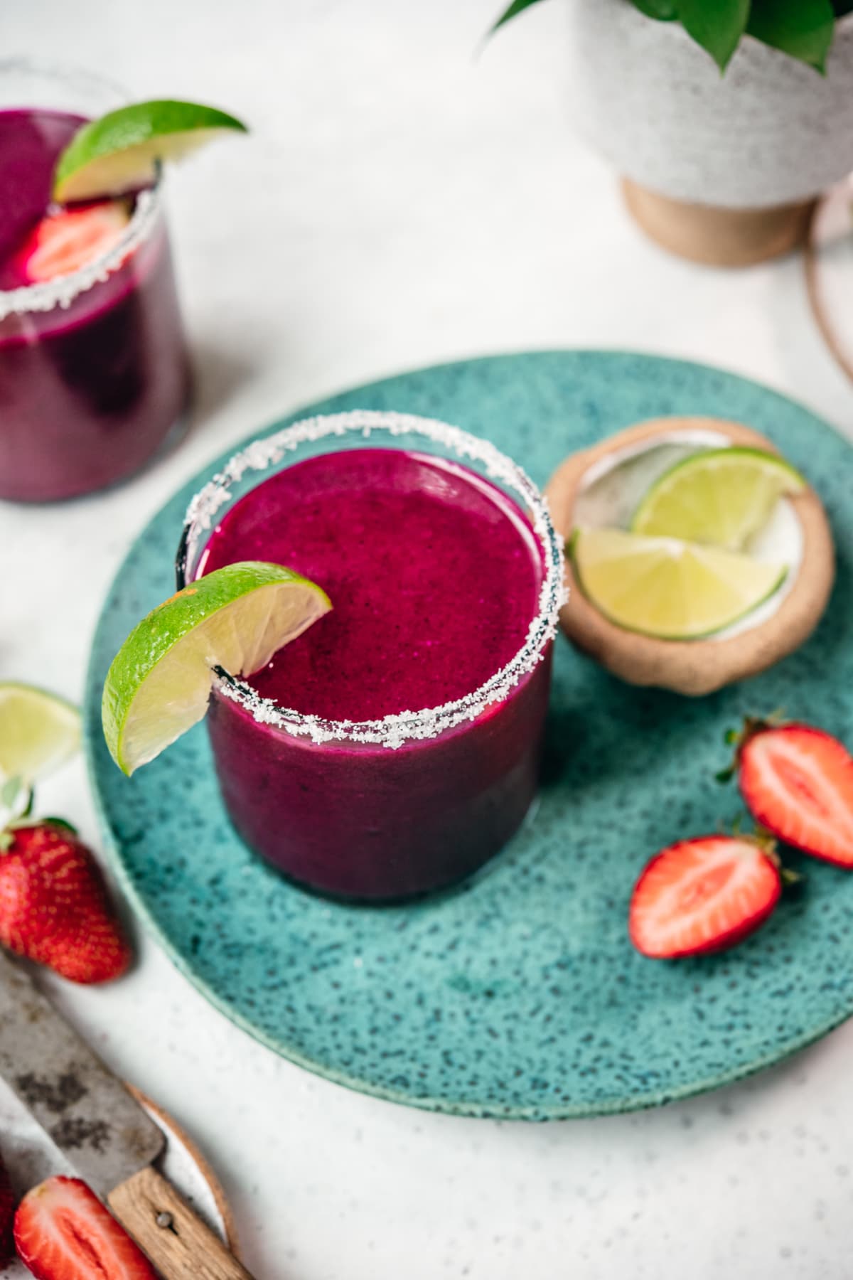 overhead view of frozen fruit margarita with lime wedge