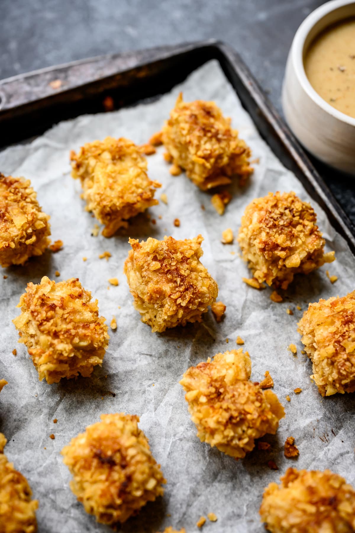 close up side view of baked tofu nuggets on sheet pan after baking