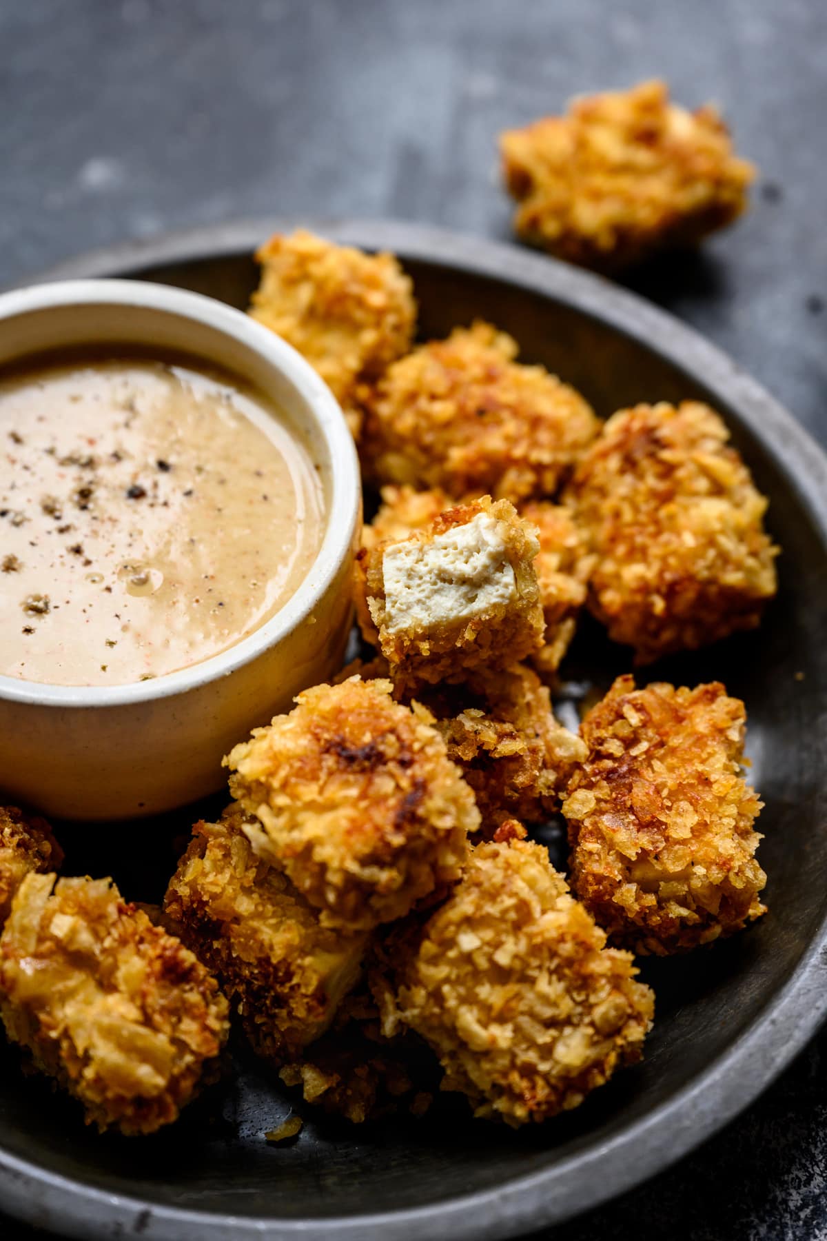 close up view of tofu nugget with bite taken out