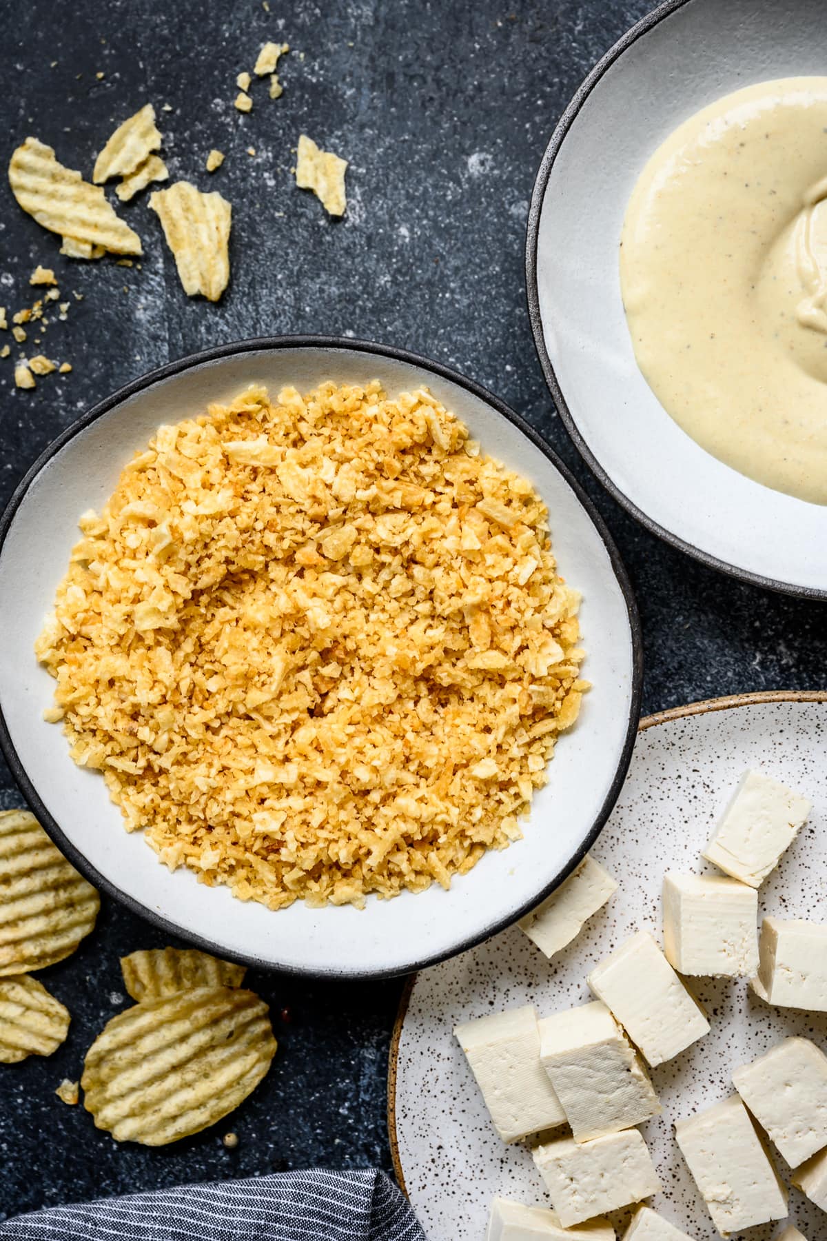 overhead view of crushed potato chips in bowl for breading tofu