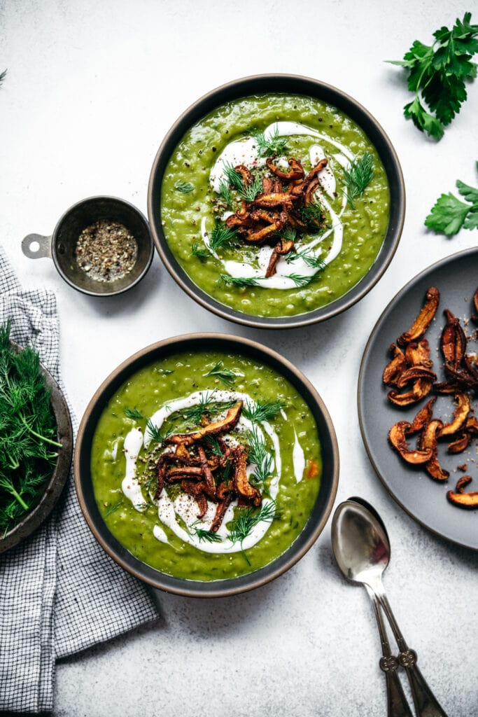 overhead view of two bowls of vegan split pea soup topped with mushroom bacon