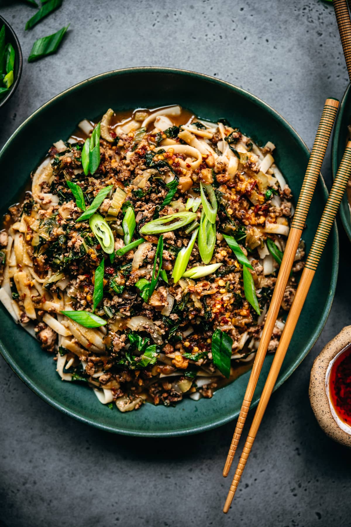 overhead view of vegan dan dan noodles in bowl with chopsticks