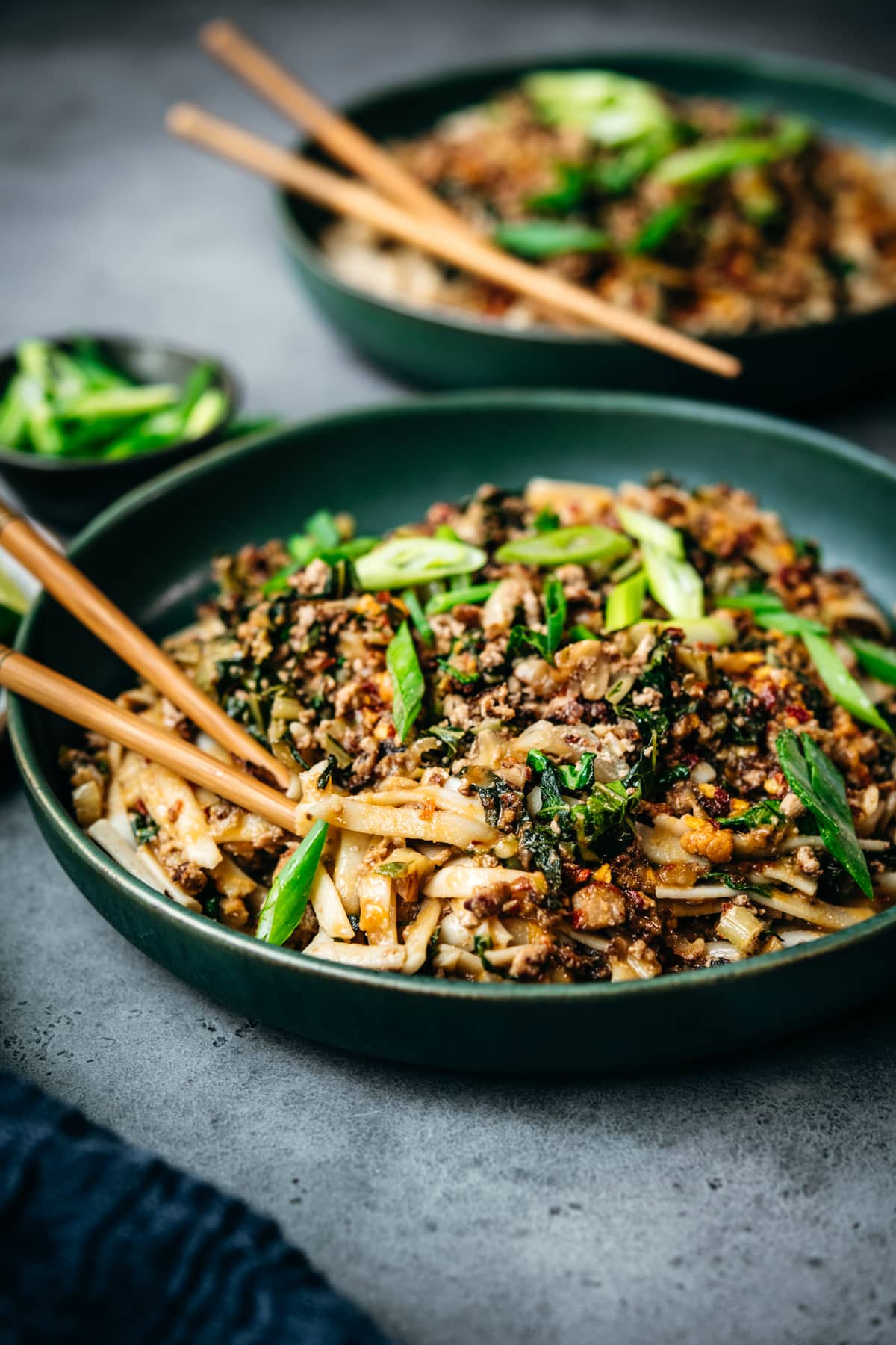 side view of vegan dan dan noodles in blue bowl