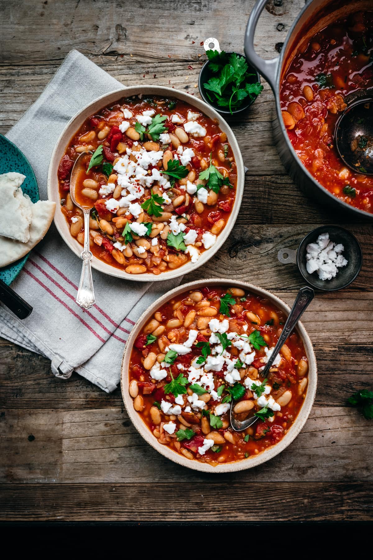 overhead view of tomato white bean stew on wood table