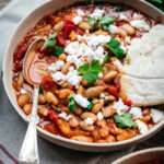 Tomato stew with a spoon and bread.