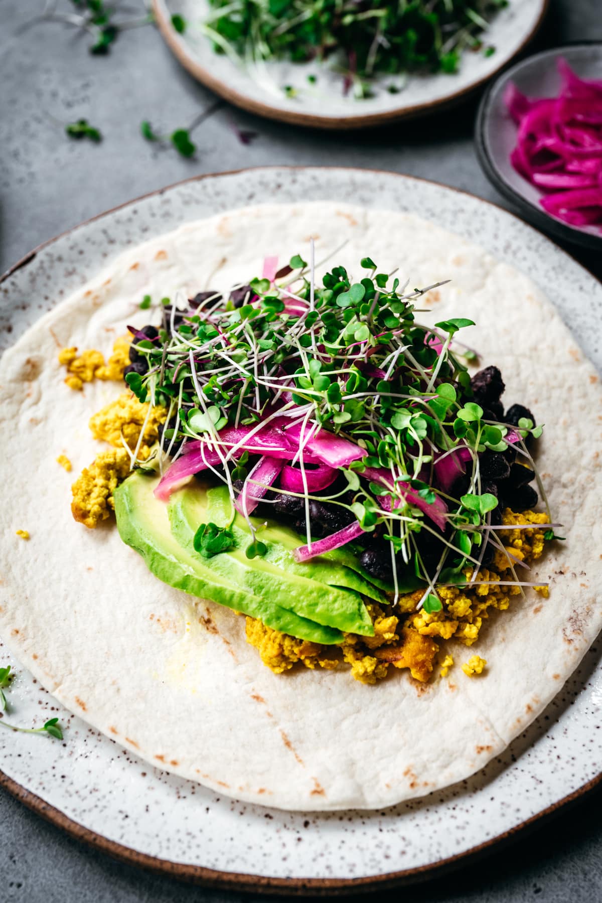 side view of open-faced vegan breakfast burrito with scrambled tofu