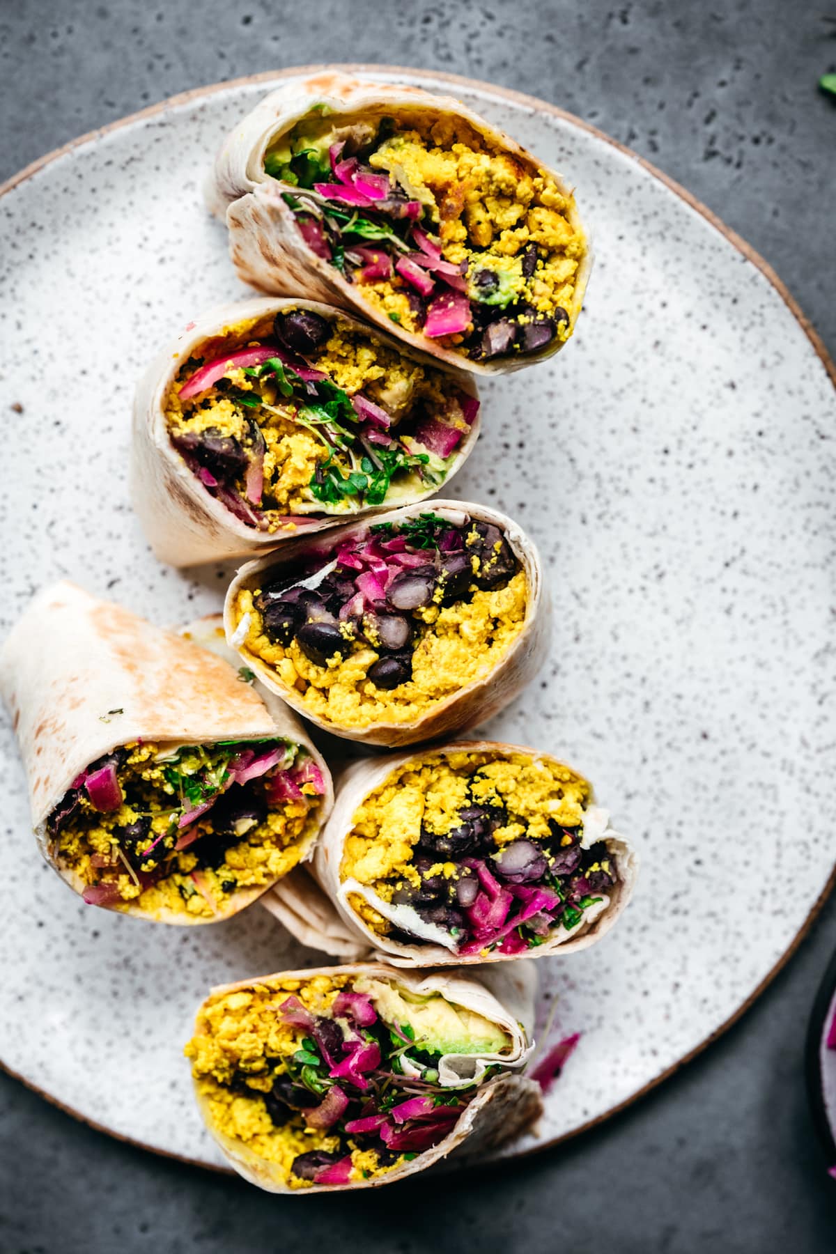 close up view of vegan scrambled tofu breakfast burritos with black beans and avocado