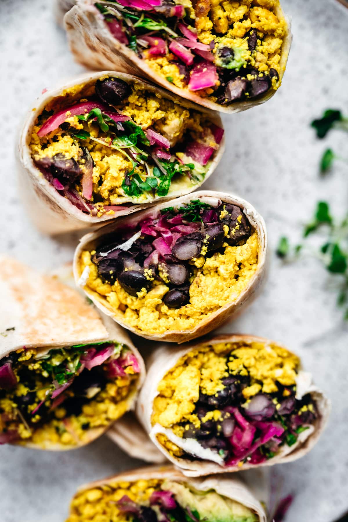 close up view of vegan scrambled tofu breakfast burritos with black beans and avocado