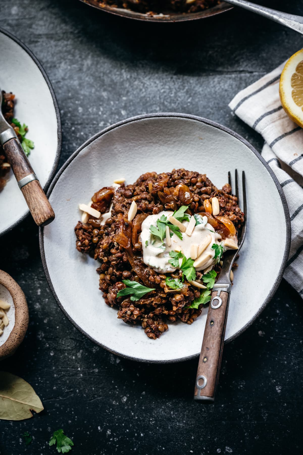 overhead view of vegan mujarada in a bowl with tahini yogurt sauce