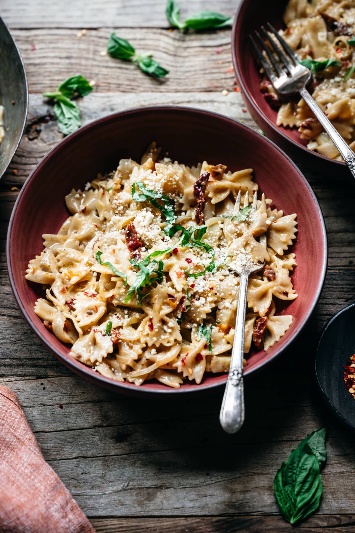 close up overhead view of vegan sun-dried tomato pasta in red bowl