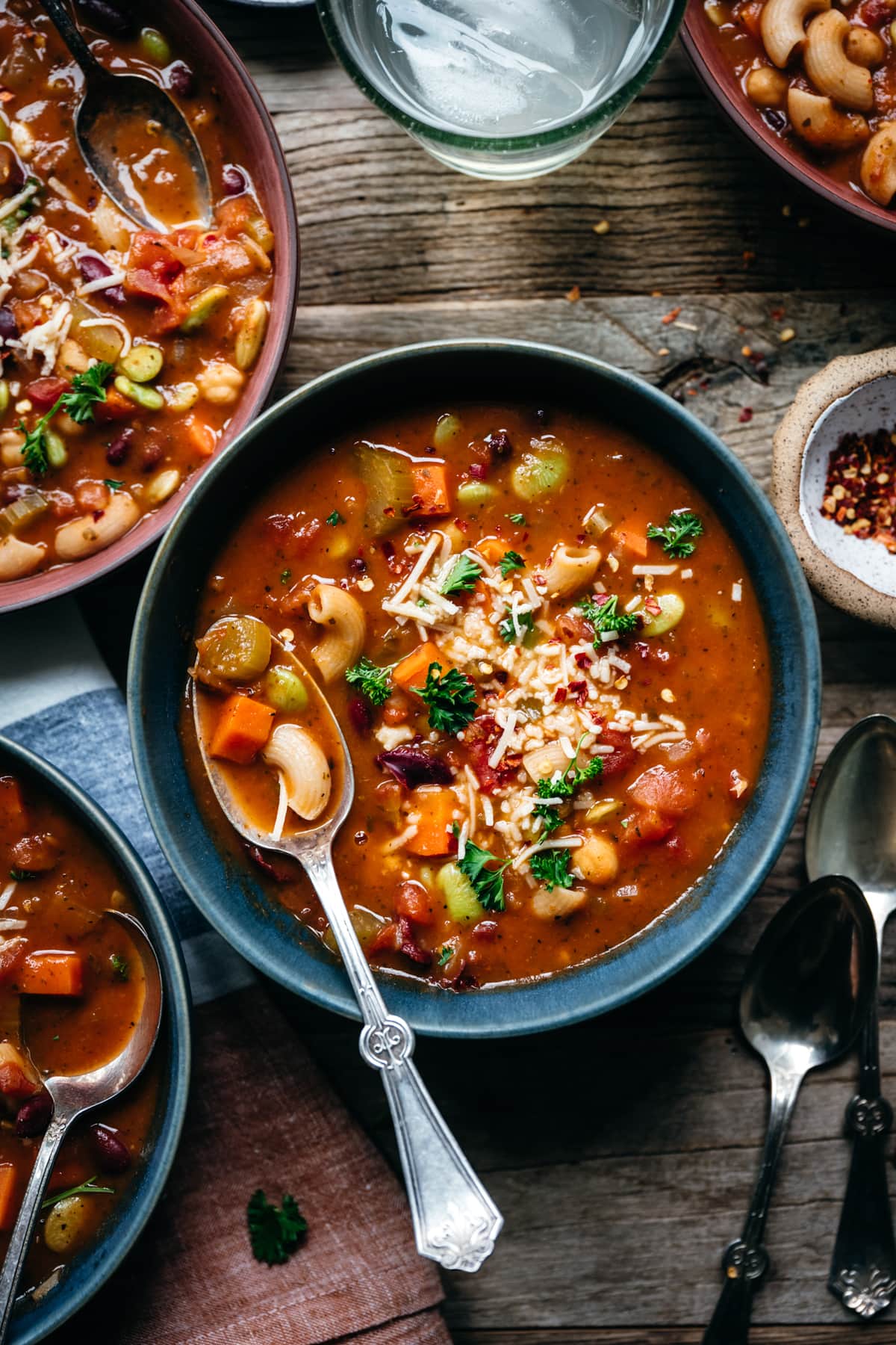 close up view of vegan minestrone soup in blue bowl