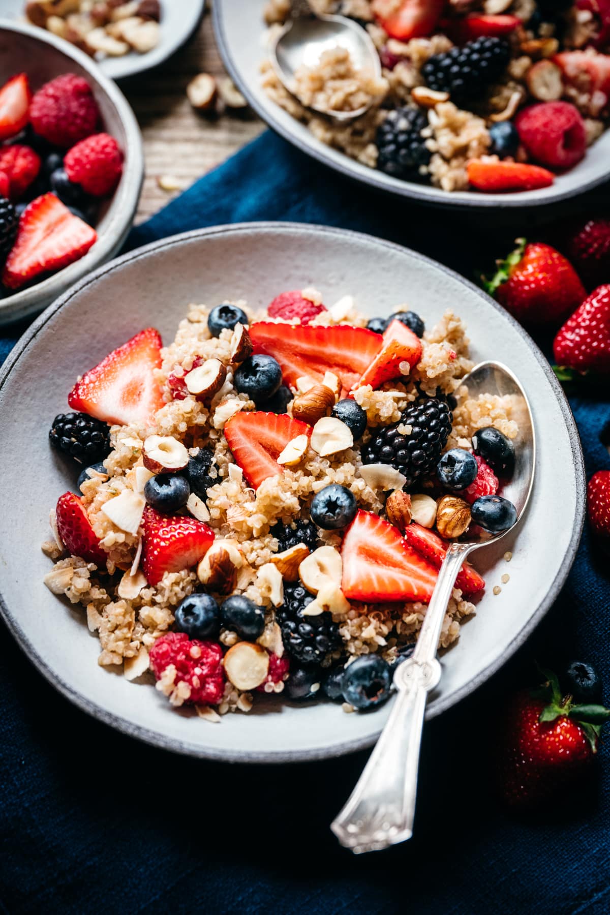 side view of coconut breakfast quinoa with nuts and berries in a bowl
