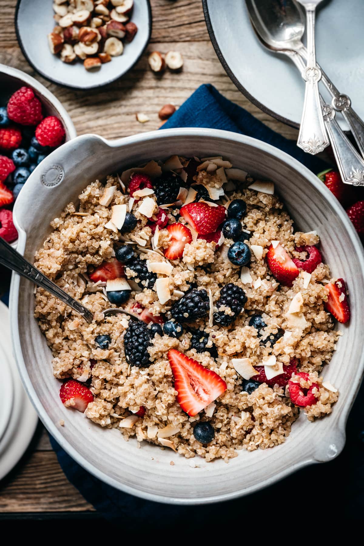 overhead view of vegan breakfast quinoa with berries and coconut in a large mixing bowl