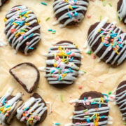 Chocolate coconut easter eggs with white chocolate and sprinkles on yellow backdrop.