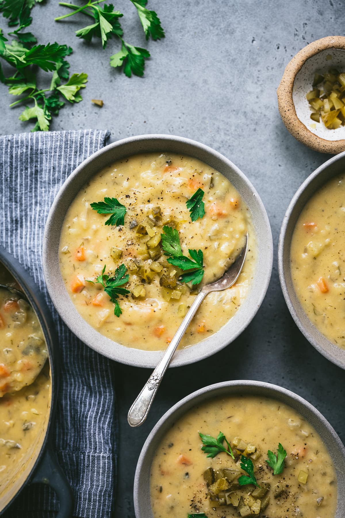 overhead view of vegan gluten free dill pickle soup in grey bowl with spoon