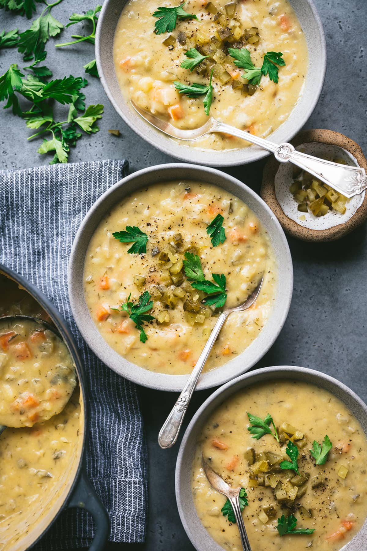 overhead view of vegan gluten free dill pickle soup in grey bowl with spoon