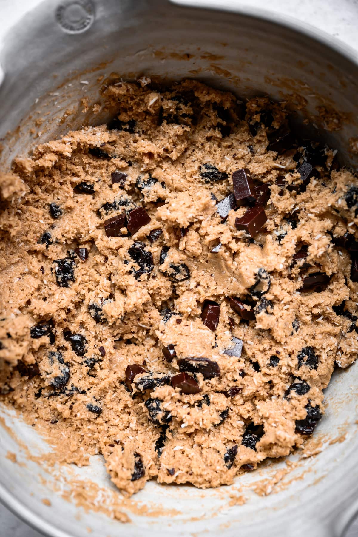 close up overhead view of chocolate chip tart cherry cookie dough in a bowl