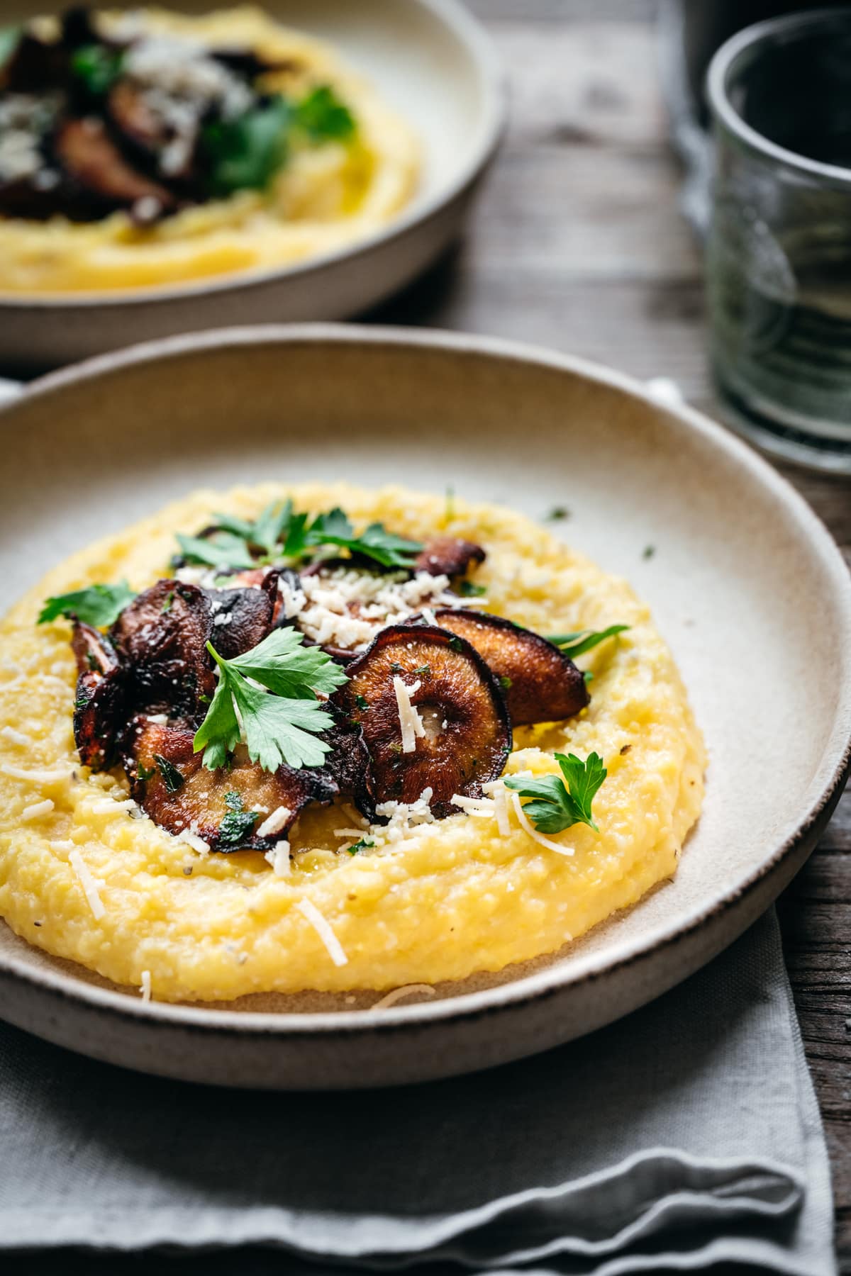 side view of creamy vegan polenta with crispy mushrooms and herbs