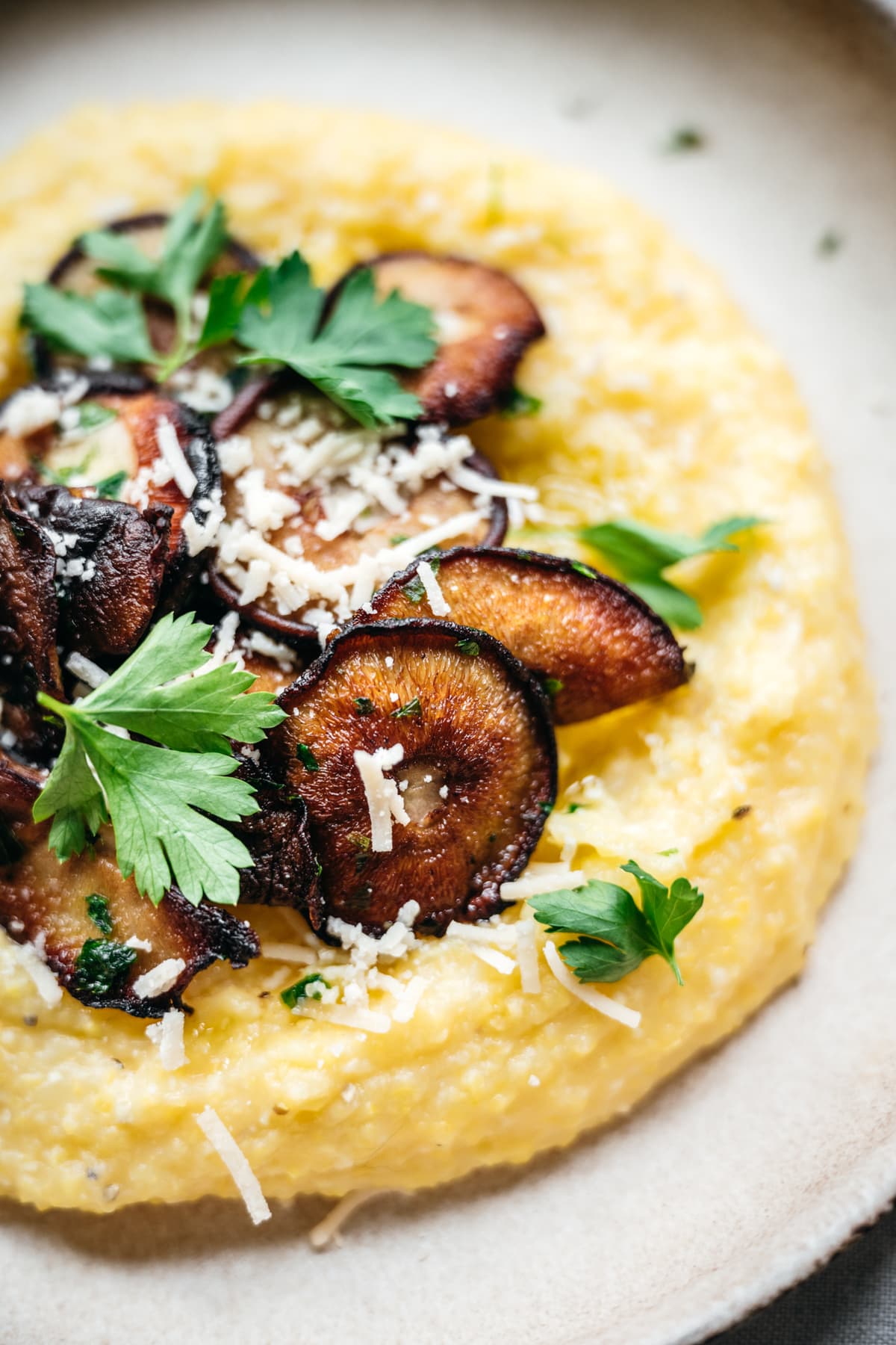 close up view of crispy mushrooms on creamy polenta