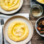 Polenta on a plate with cheese grated on top of it.