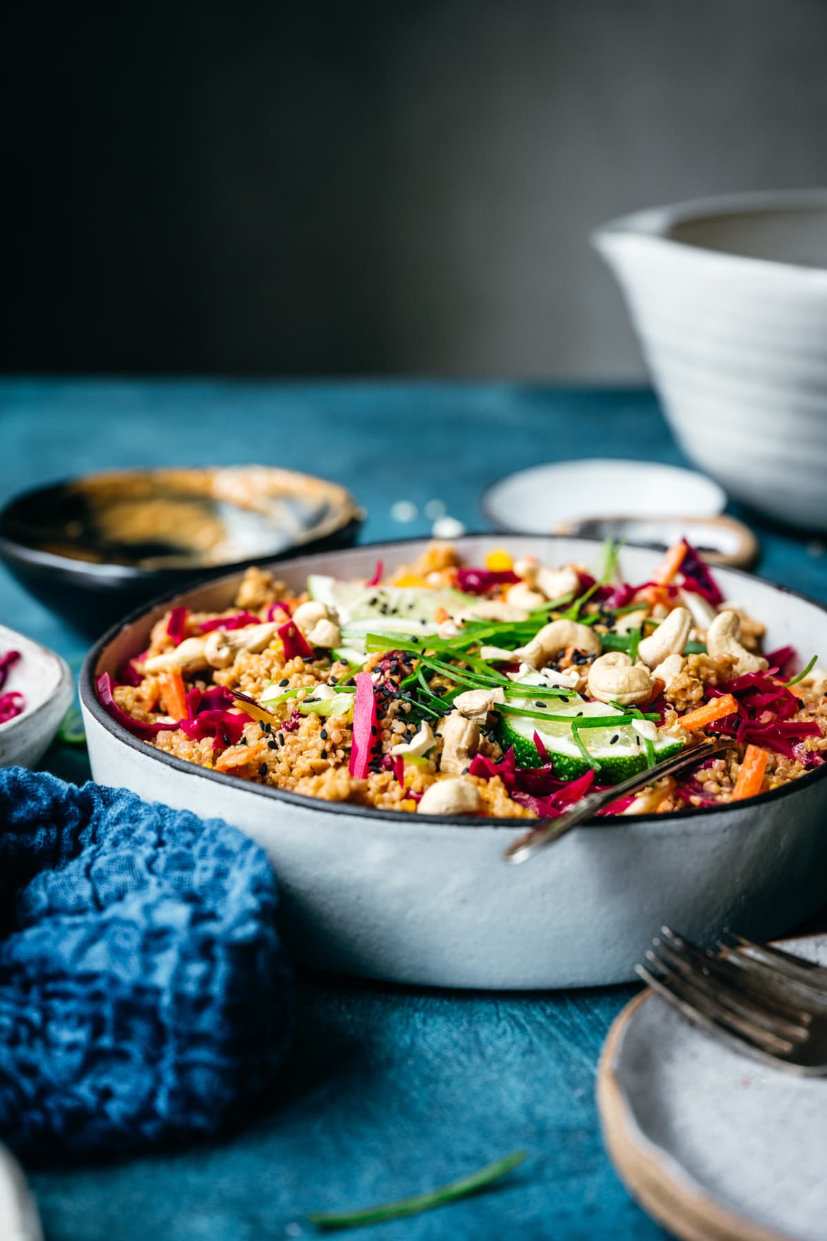 side view of vegan thai quinoa peanut salad in a white bowl