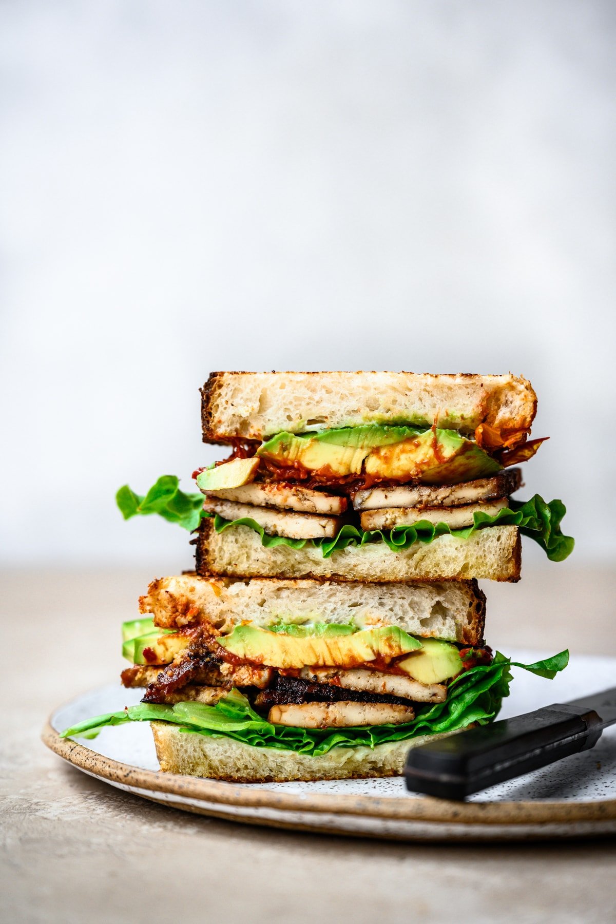 side view of vegan blt cut in half on plate