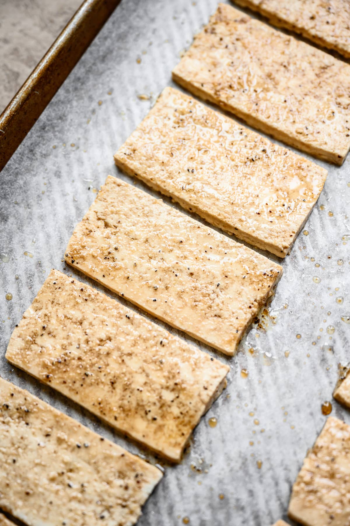 side view of uncooked vegan tofu bacon on sheet pan