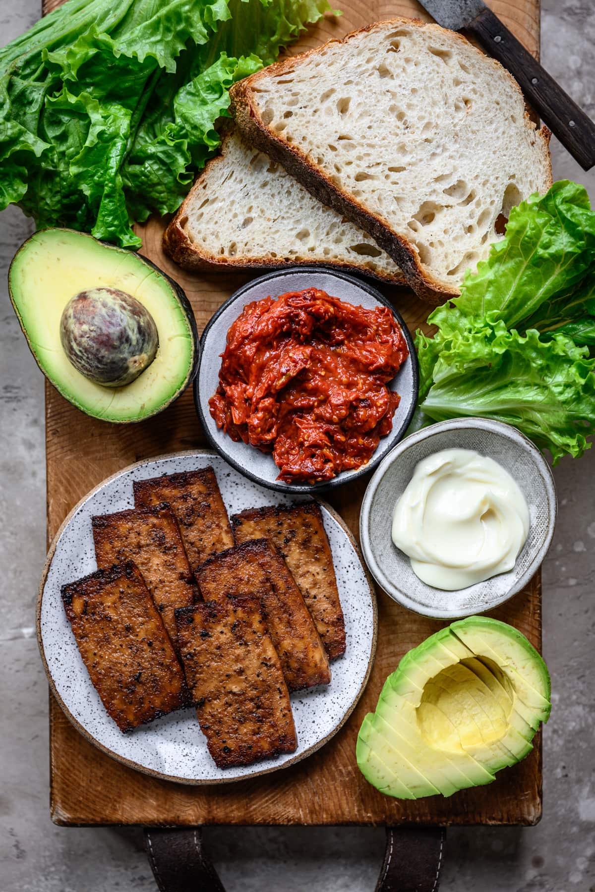 overhead view of ingredients for a vegan BLT sandwich with tofu bacon