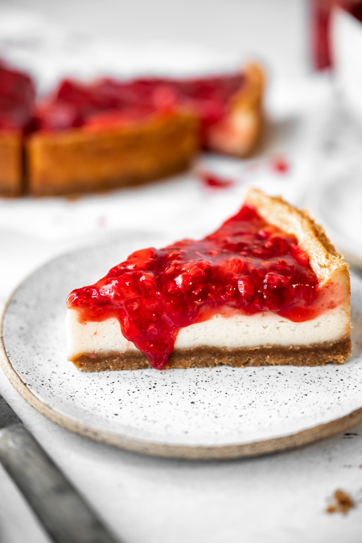 close up side view of a slice of baked vegan cheesecake