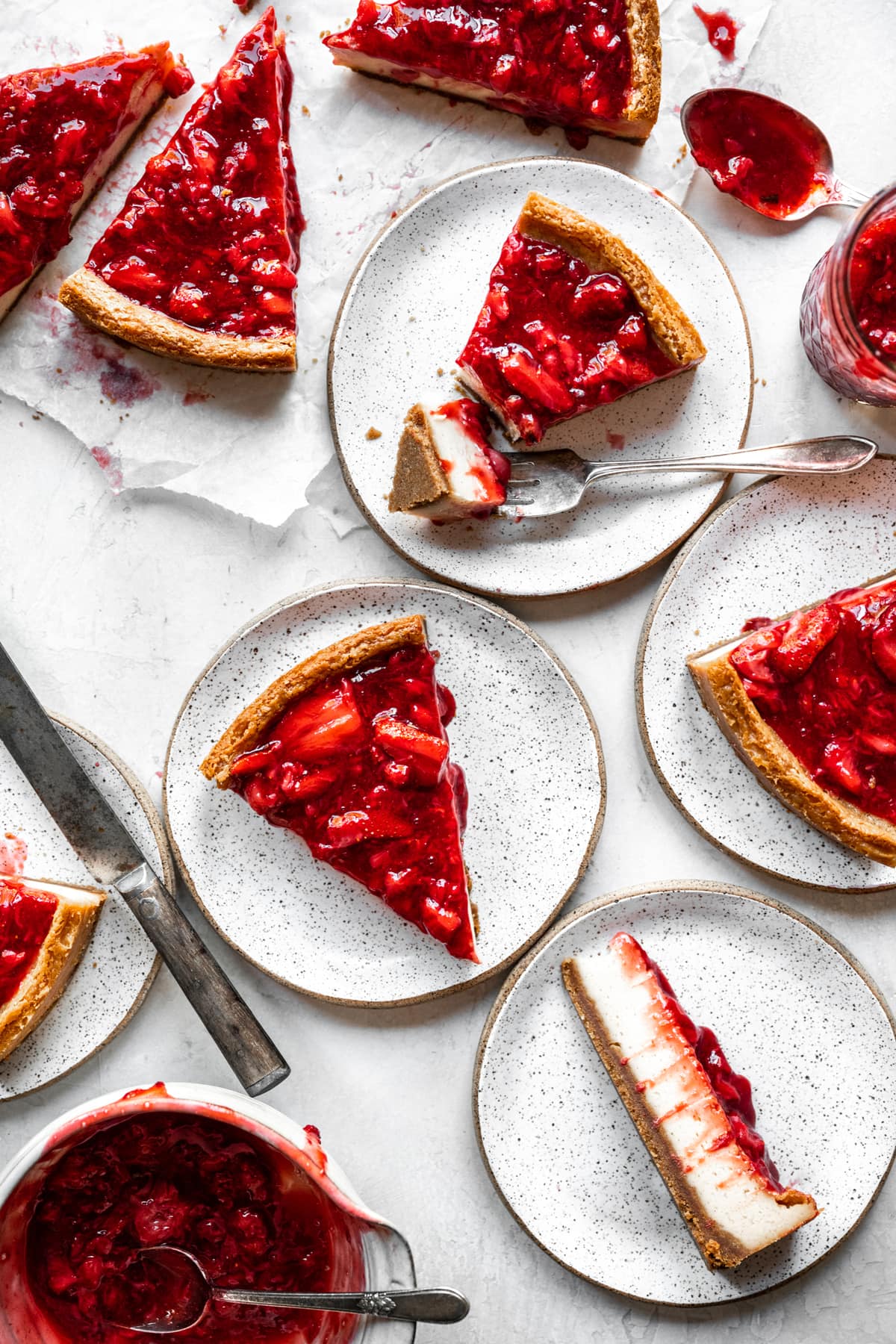 overhead view of slices of strawberry vegan cheesecake on small plates