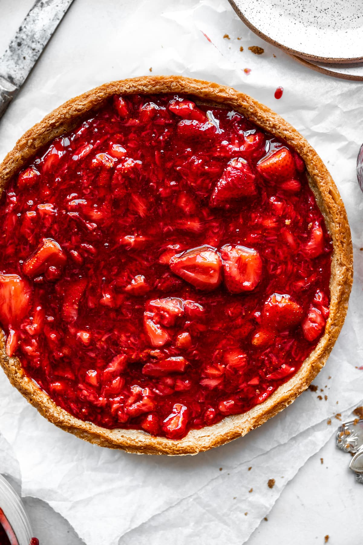 overhead view of classic vegan cheesecake with strawberry sauce