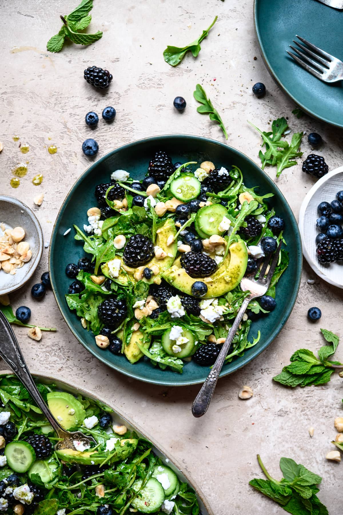 overhead view of blackberry avocado arugula salad in blue bowl