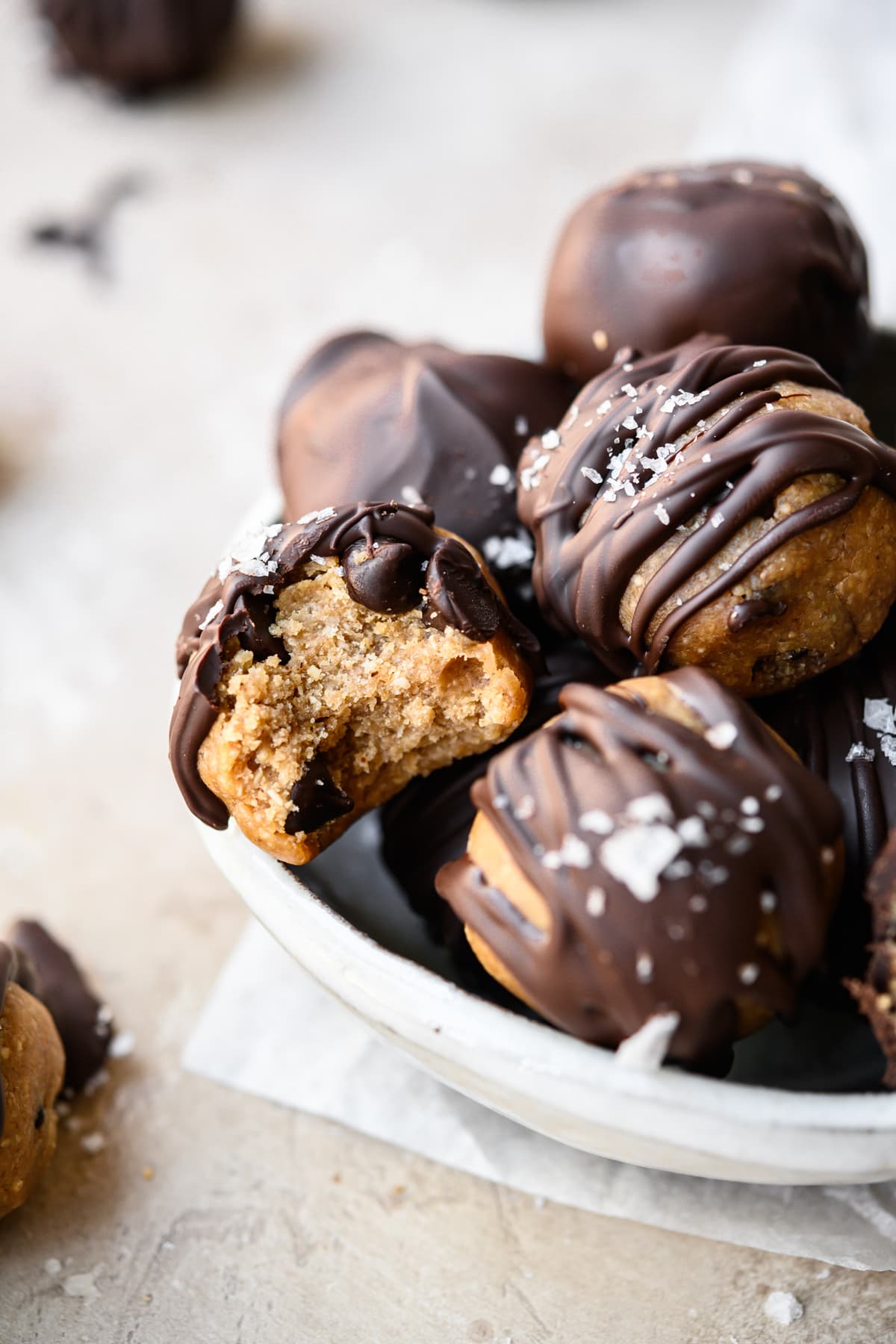 close up view of chocolate covered cookie dough bite with bite taken out