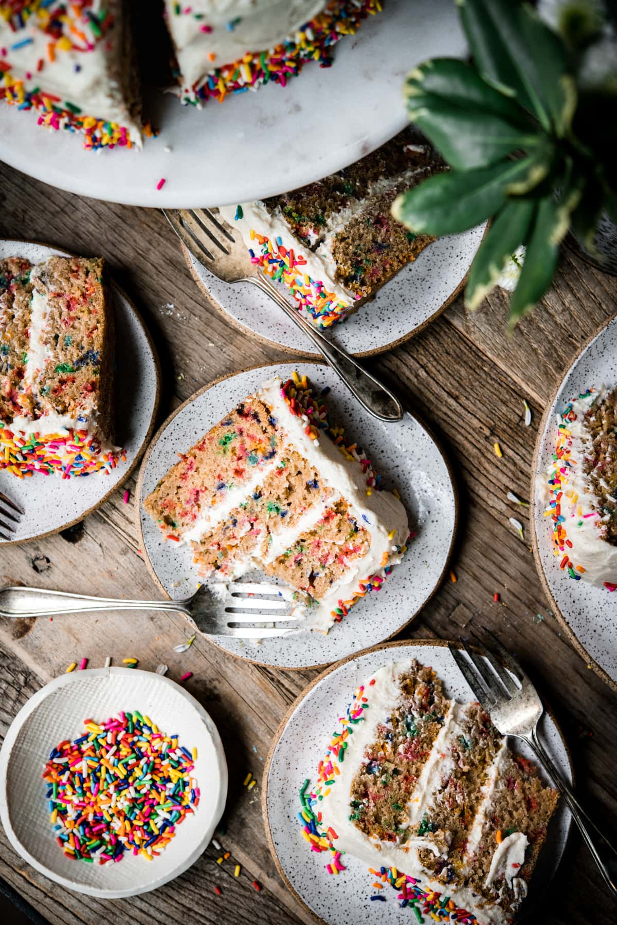 overhead view of multiple slices of vegan gluten free funfetti cake on small plates