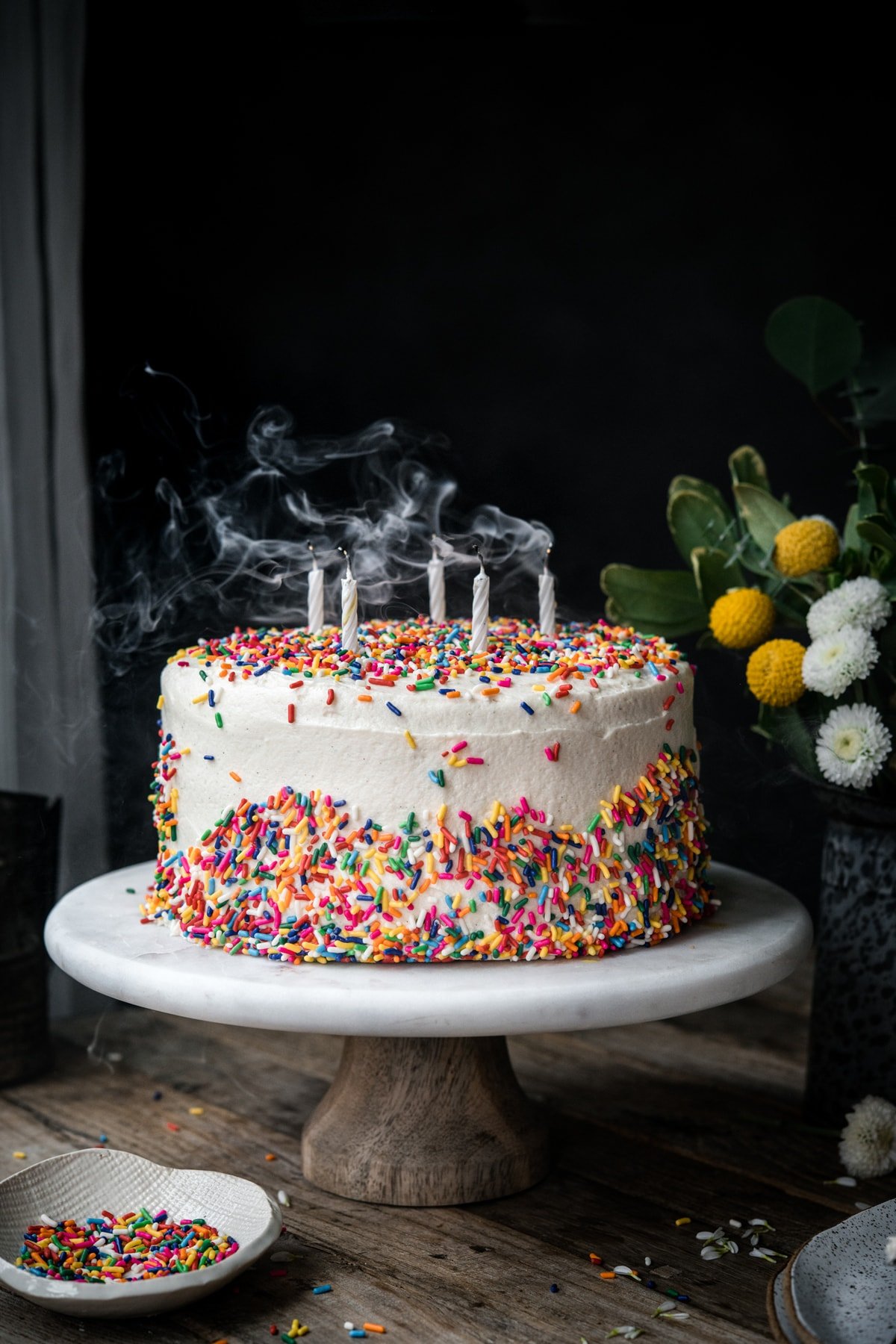 side view of vegan gluten free birthday cake with candles blown out