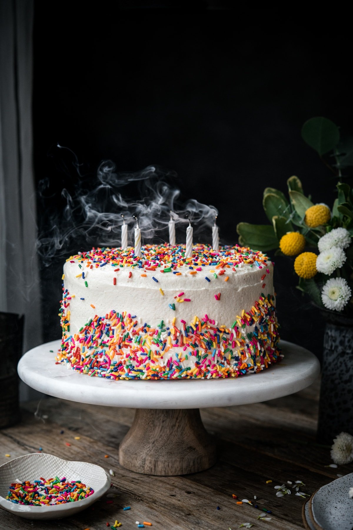 side view of vegan gluten free birthday cake with candles blown out 