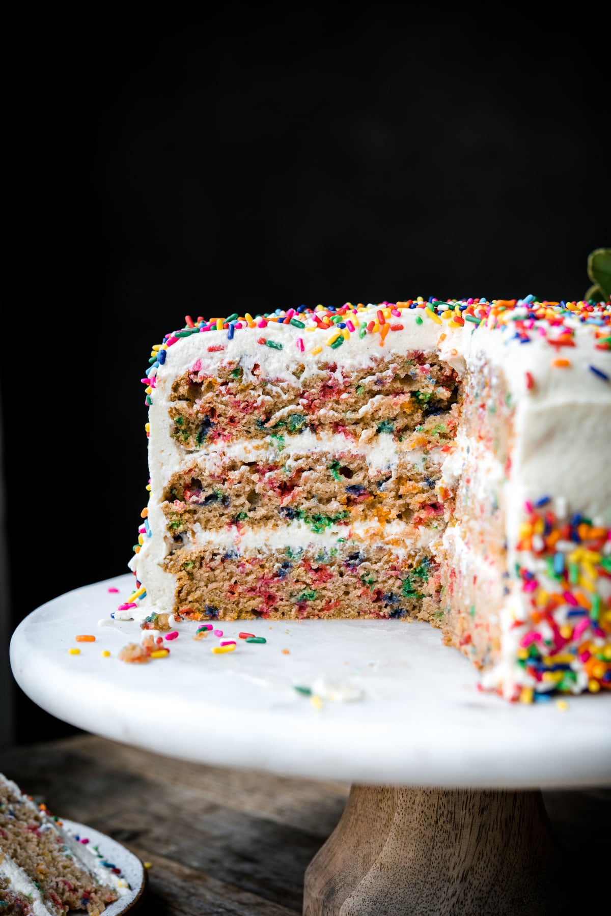 close up side view of slice of vegan gluten free funfetti cake with 3 layers