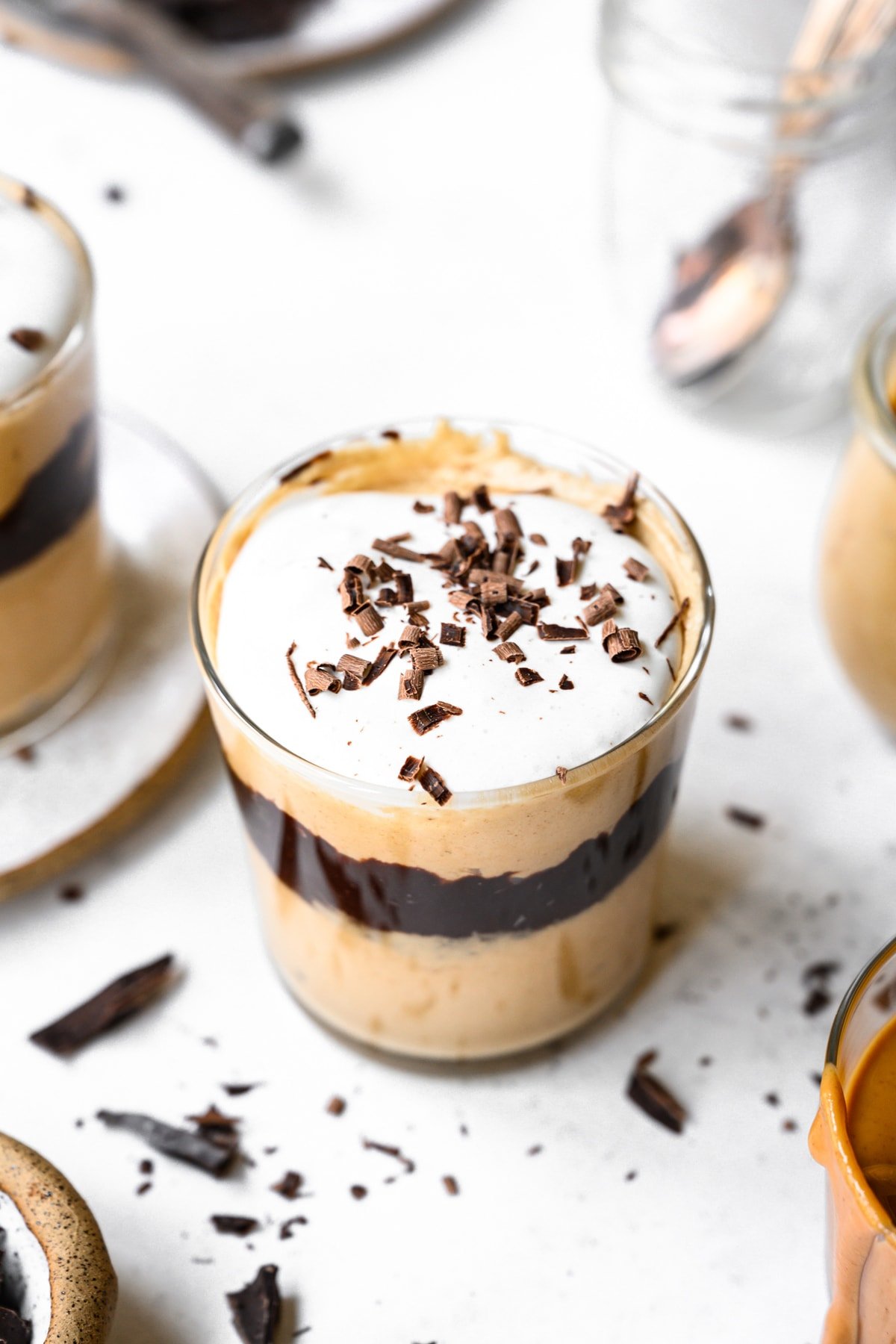 close up view of vegan peanut butter mousse topped with whipped cream and chocolate shavings