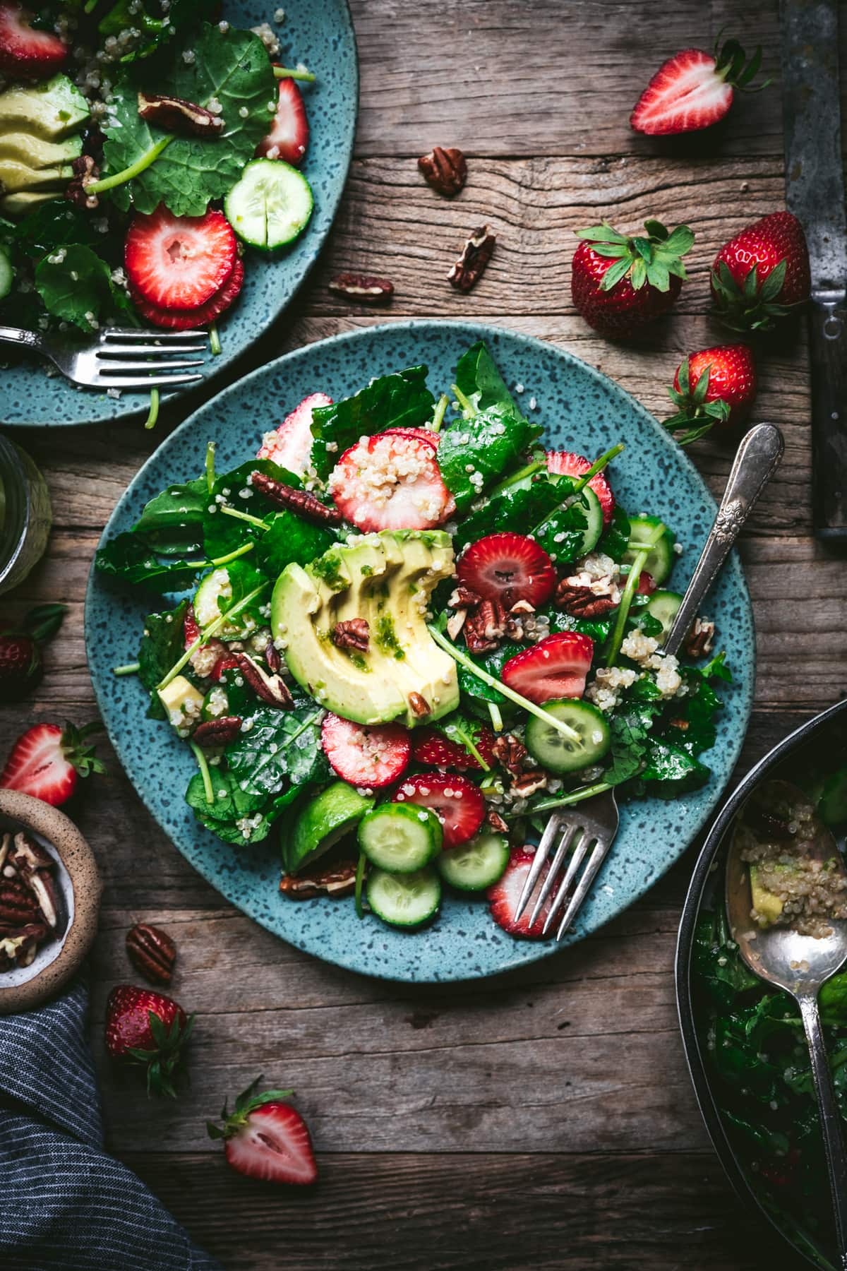 overhead view of strawberry quinoa avocado salad on blue plate