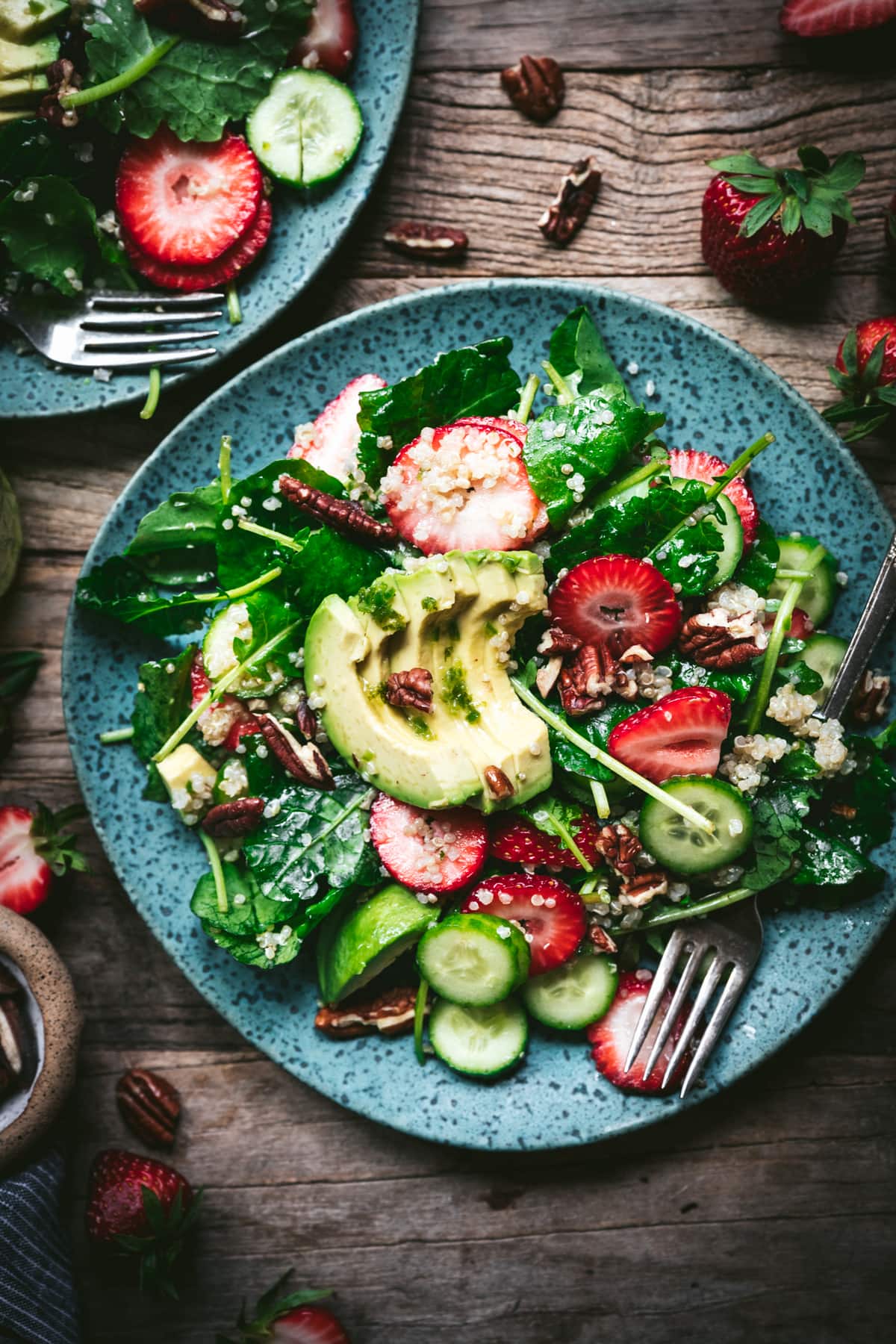 overhead view of strawberry quinoa avocado salad on blue plate