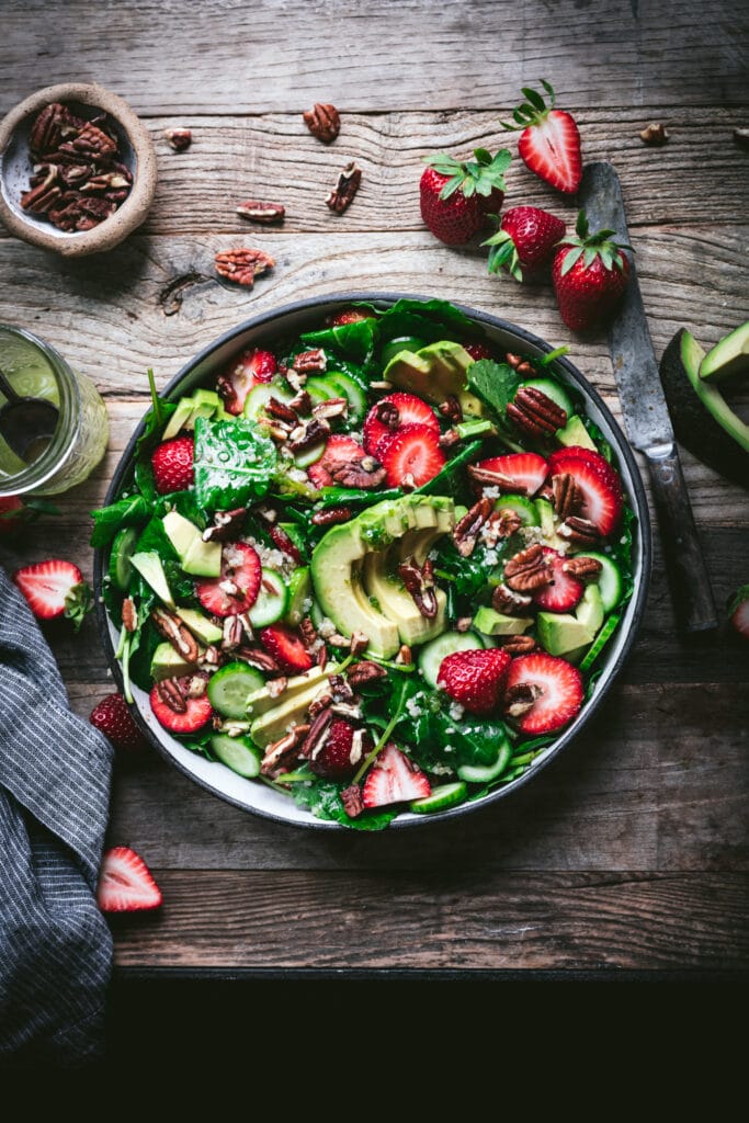 overhead view of strawberry avocado quinoa salad in a white salad bowl