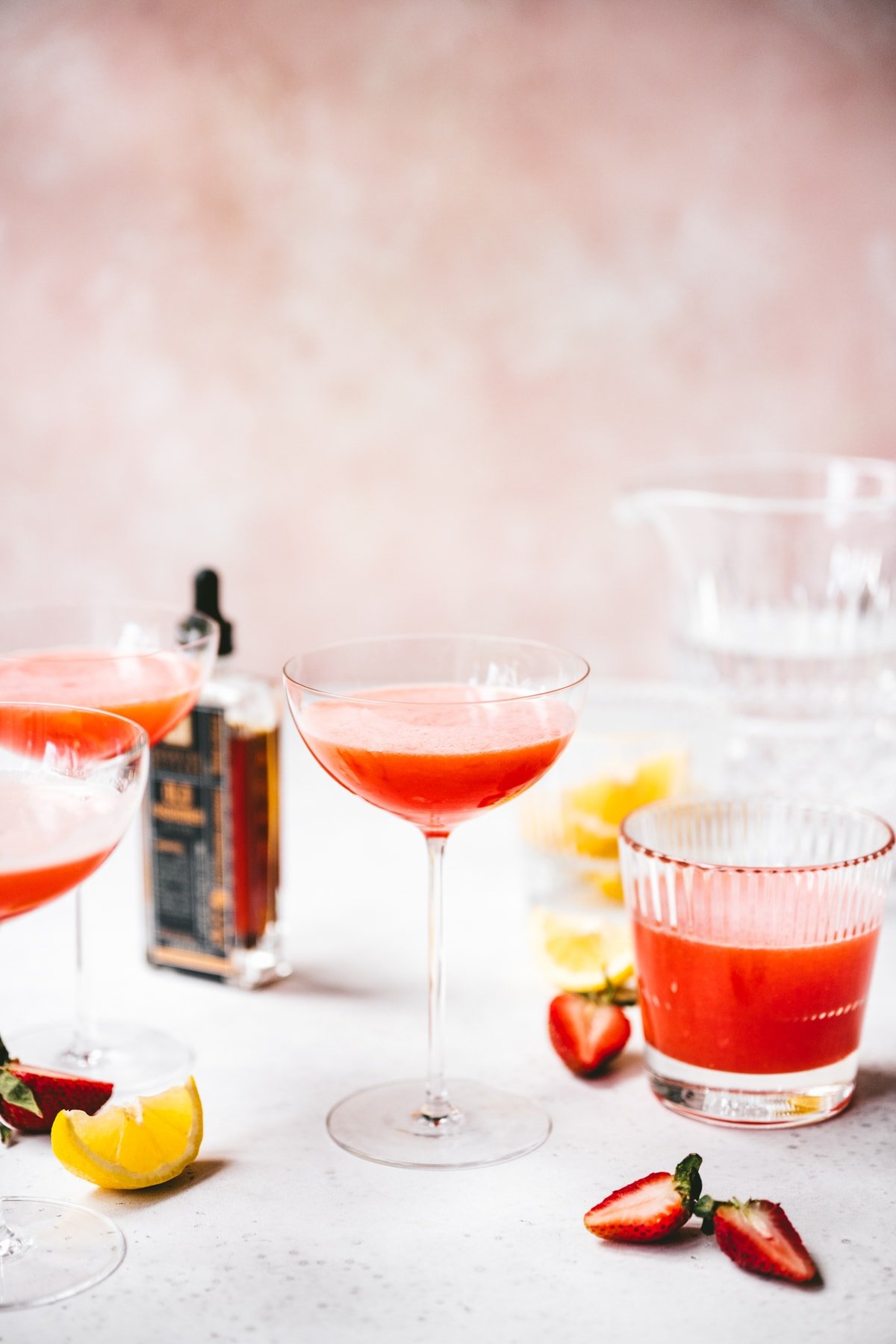 side view of vegan strawberry pisco sour in a coupe glass