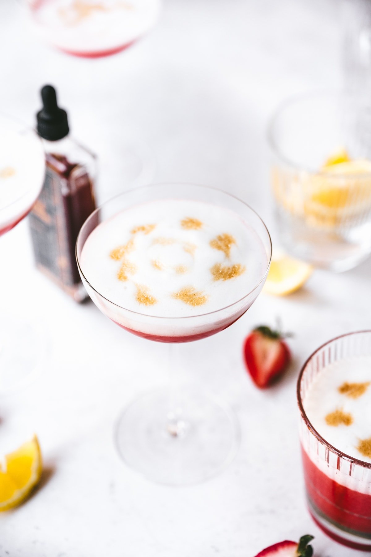 side view of vegan strawberry pisco sour in a coupe glass